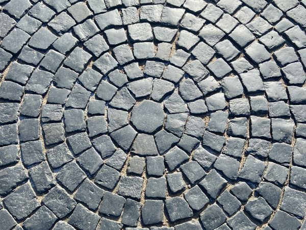 Circular pattern of stone cobblestones on the ground.