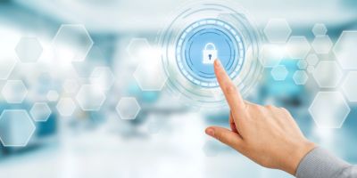 Hand touching digital lock icon on futuristic interface.