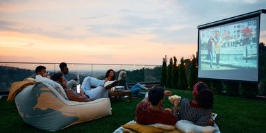 Outdoor projector setup with:

• Cozy seating

• Popcorn bar

• Candy station

• Beach blankets
