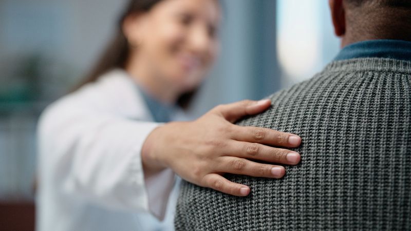 Consultation, woman and doctor with empathy, support and advice with hospital healthcare service. Comfort, trust, medical professional in office with patient, discussion and helping hand for wellness