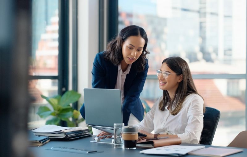 Business people, laptop or learning in training in discussion or conversation for news, education or advice. Teamwork, woman coaching or leader talking for online data or new job in digital agency