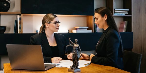 Dos mujeres en una reunión de trabajo en oficina elegante.