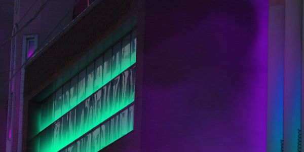 Urban building illuminated with green and purple neon lights at night.