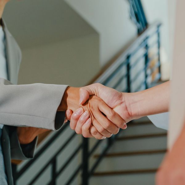 Two people shaking hands indoors closing a real estate sale