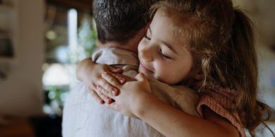 Child happily hugging an adult.