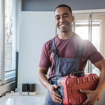 Handyman holding toolbox with sincere smile.