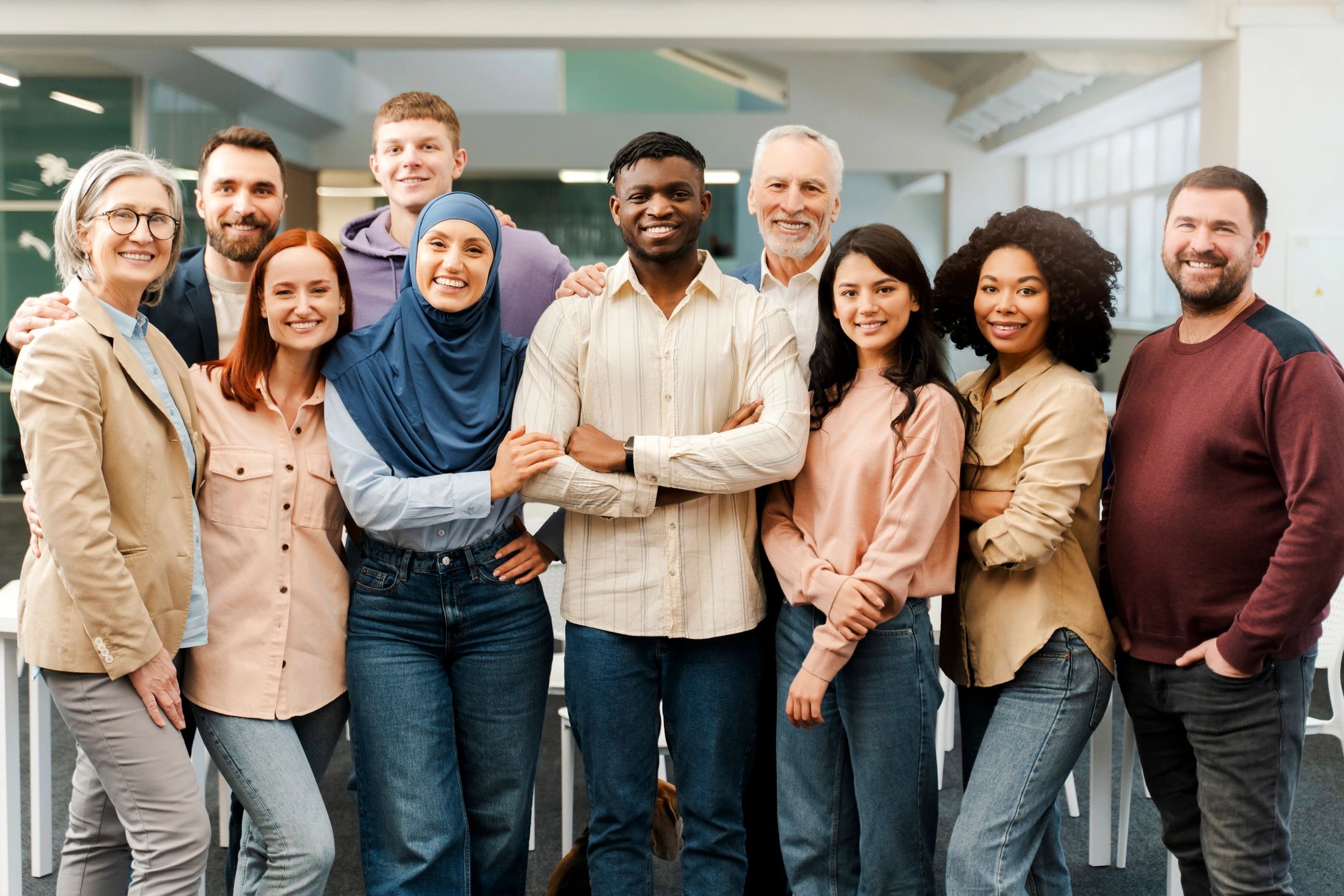 group of diverse people standing, facing the camera and smiling.