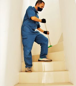 Person cleaning stairs with a broom.
