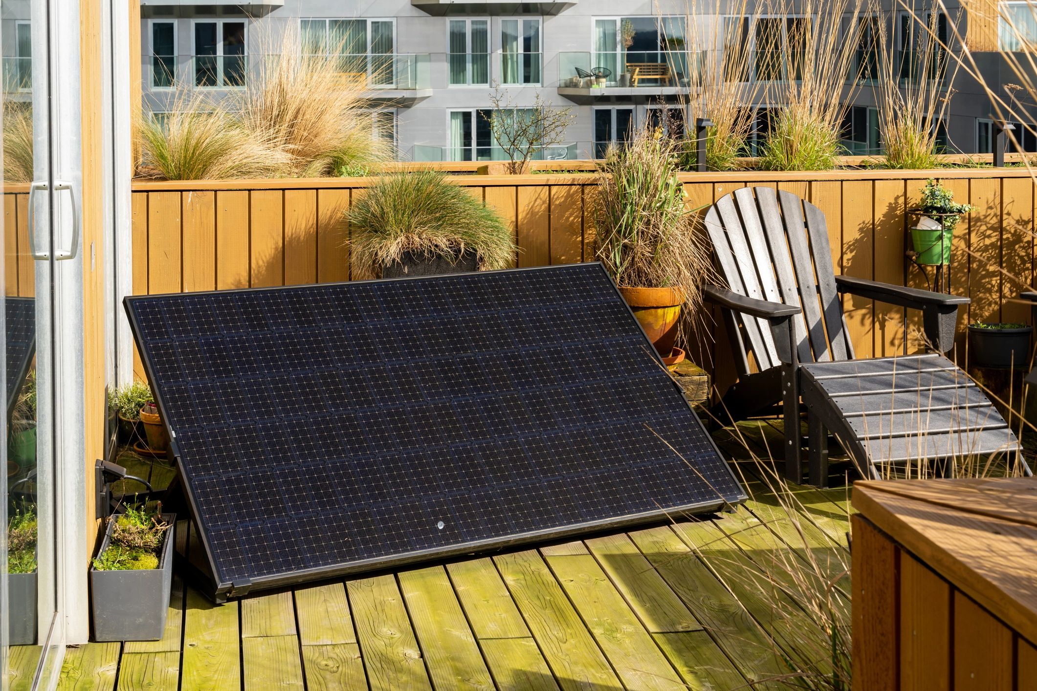Solar panel anchored on decking, with a chair at the side of it.
