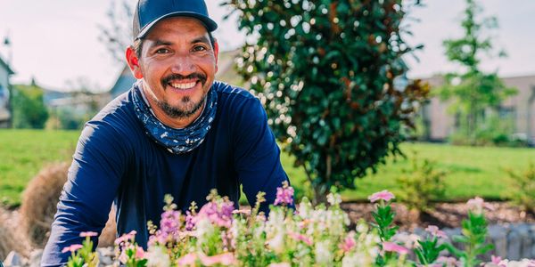 Smiling man gardening in a sunny park.