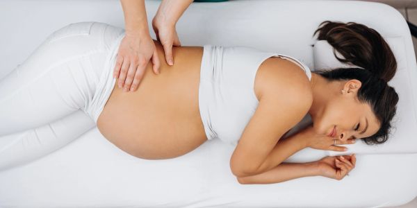 Pregnant woman receiving a gentle abdominal massage.