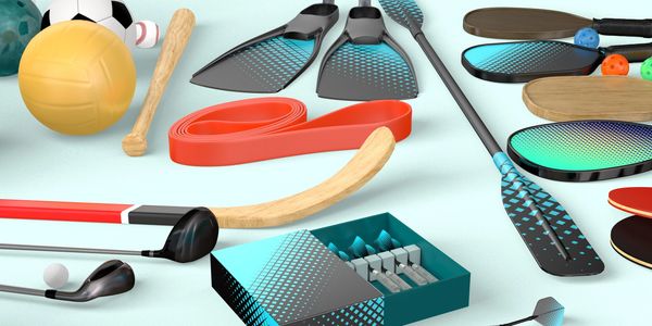 Various sports equipment including paddles, balls, and sticks arranged on a surface.