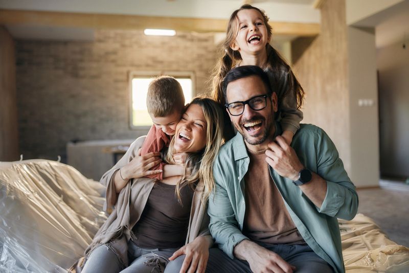 Cheerful parents having fun with their small kids after moving into a new home.