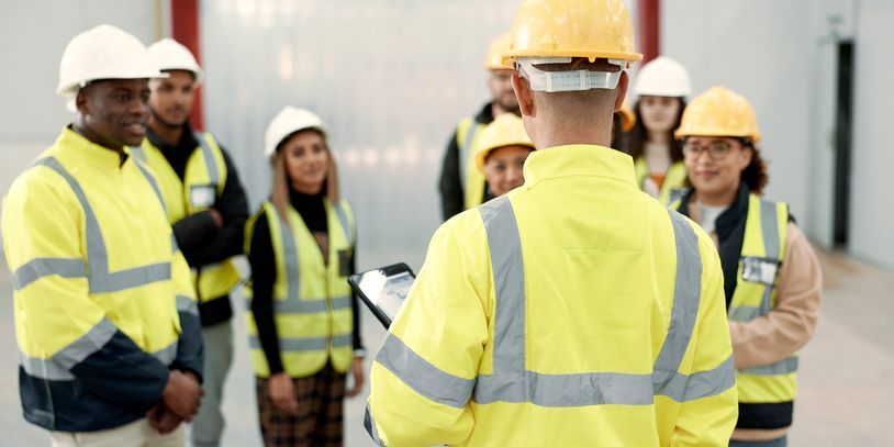 Team of construction workers in safety gear during briefing.