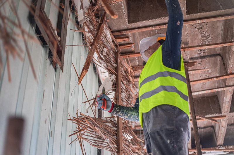 A construction worker is renovating an apartment, demolishing the old one