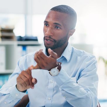 Man in blue shirt explaining with hand gestures during a conversation.