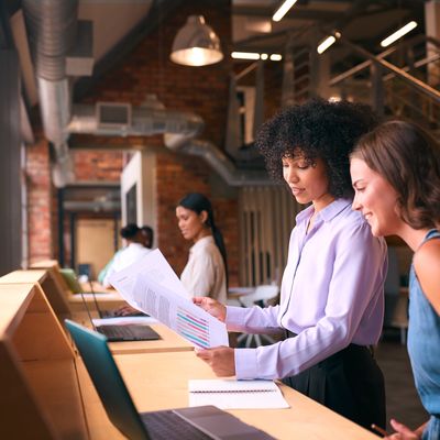 Scientists working in the office looking at maps and statistical analysis.