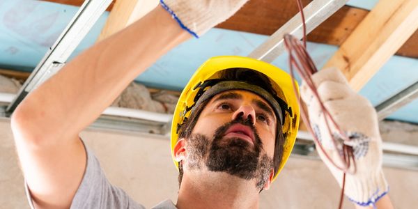 Electrician working on wiring in a construction site.