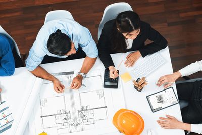 Group of professionals discussing architectural plans around a table.