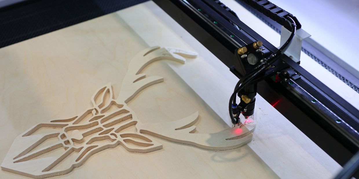 Laser cutting deer design in wood.