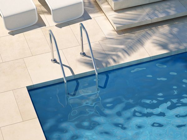 Modern poolside with white loungers and clear blue water.