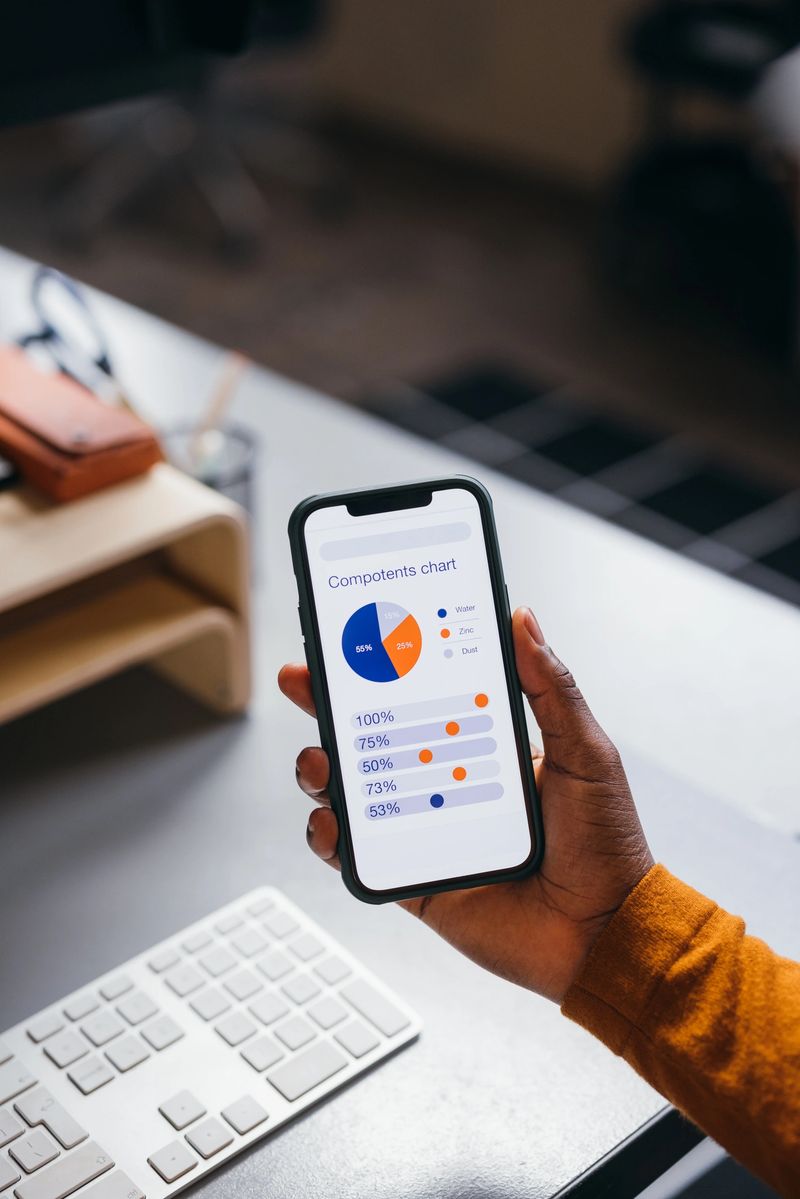 Person analyzing pie chart on smartphone at desk, a close up.