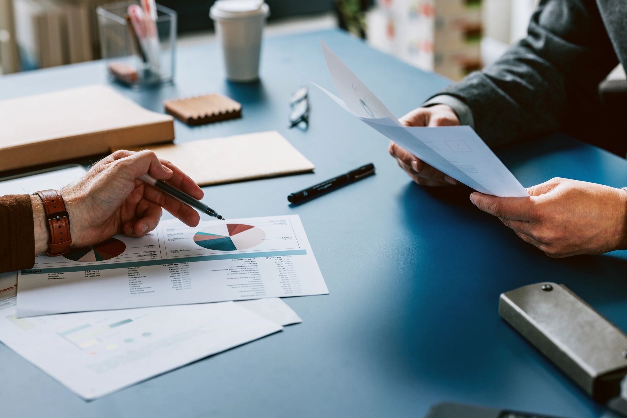 Two people discussing financial documents at a desk.