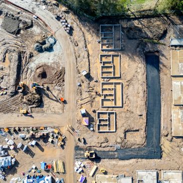 Aerial view of a residential construction site with foundation work underway.