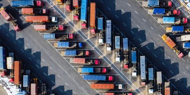 Aerial view of numerous parked cargo trucks in a logistics yard.