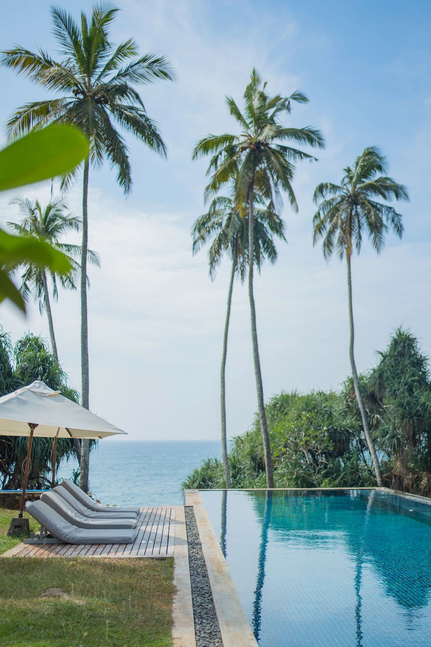 Modern city skyline with illuminated skyscrapers and yachts on the water at dusk.