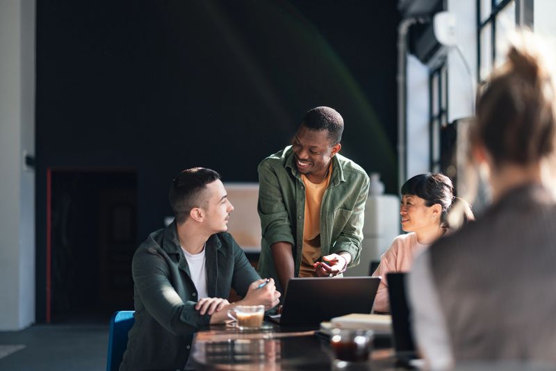Young professionals engaging in a collaborative work session in a sunlit, trendy co-working environment.