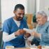 Caregiver and elderly woman sharing a moment with photos.