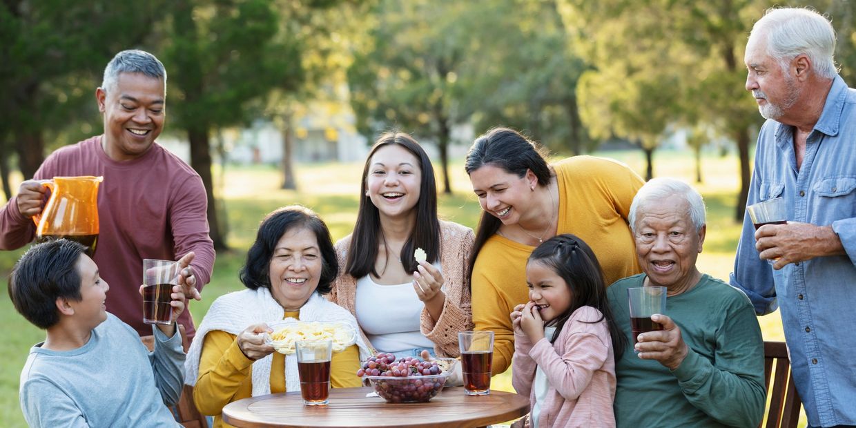 Family enjoying snacks and drinks outdoors around a table.