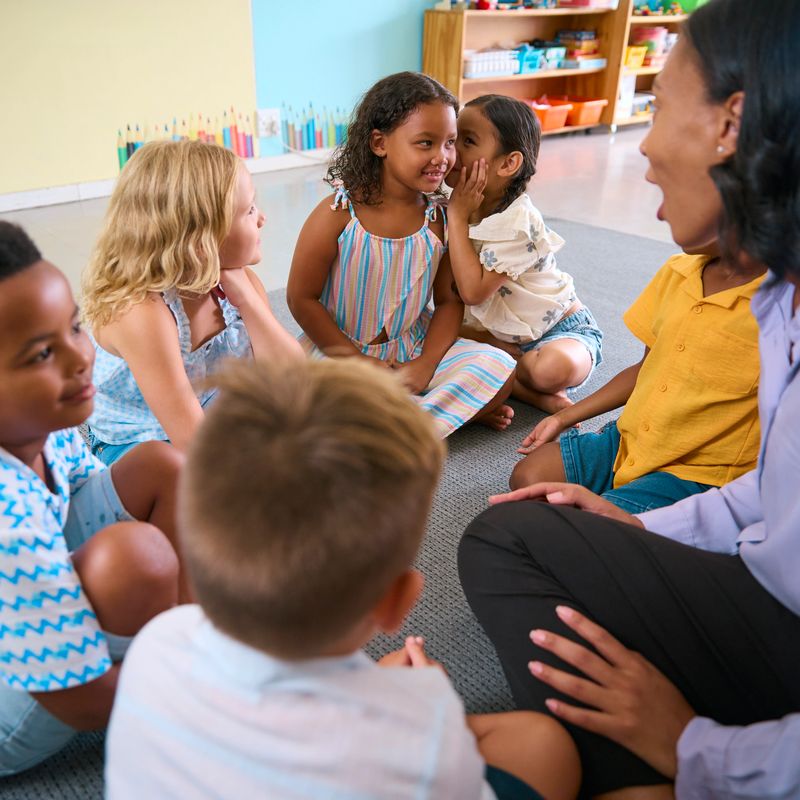 Multi-Cultural Primary Or Elementary School Class With Students Whispering To Each Other