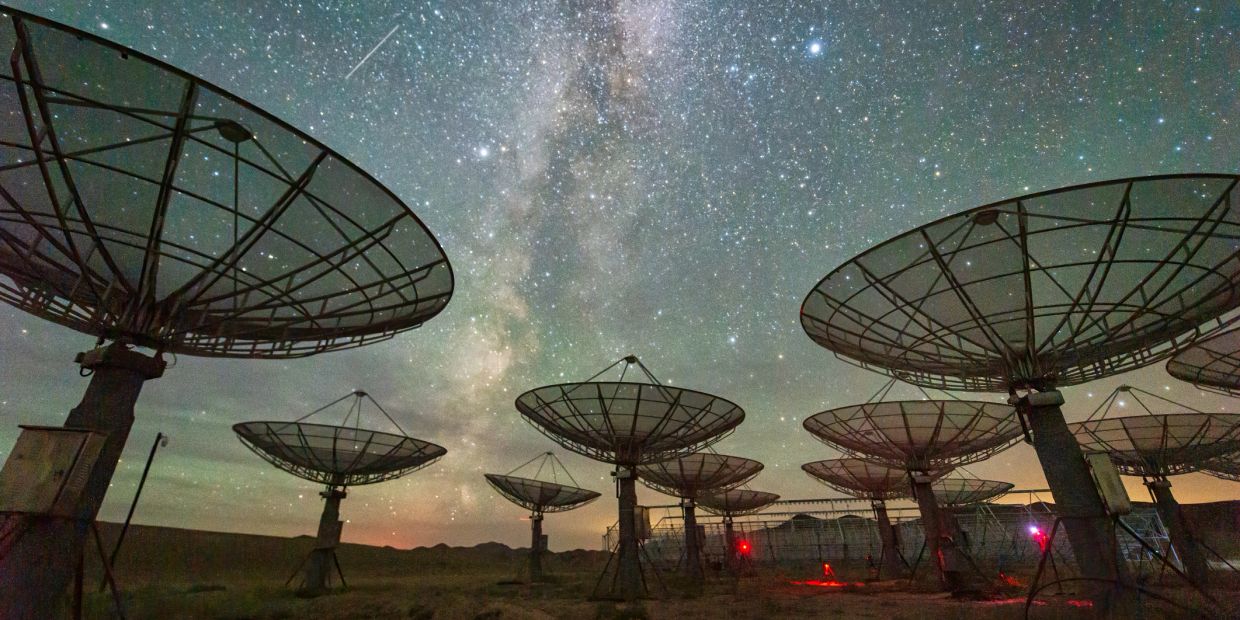 Radio telescopes under a starry sky.