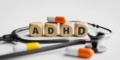 Wooden blocks spell ADHD with a stethoscope and pills.