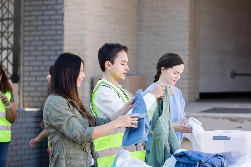 The diverse group of volunteers help organize clothes at the donation event.