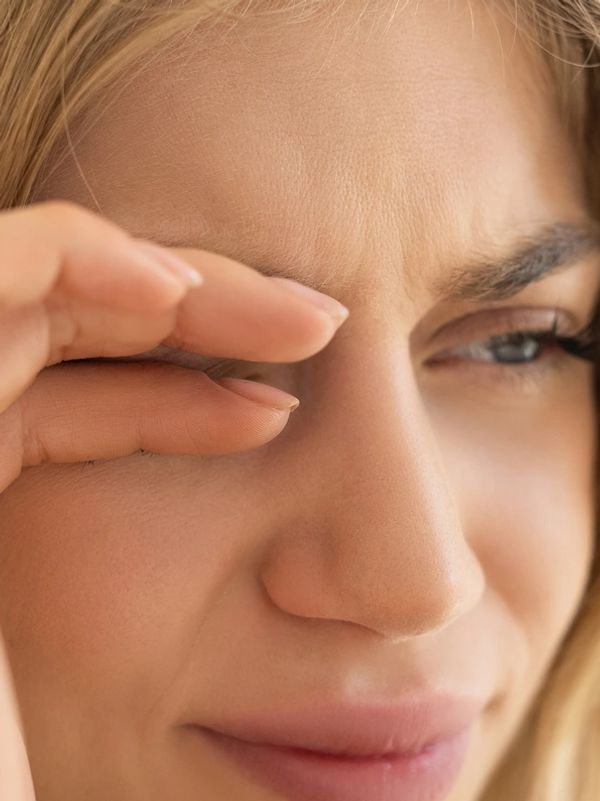 Close-up of a woman rubbing her eye.