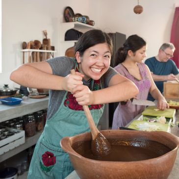 Mujer batiendo chocolate con alegría en cocina.