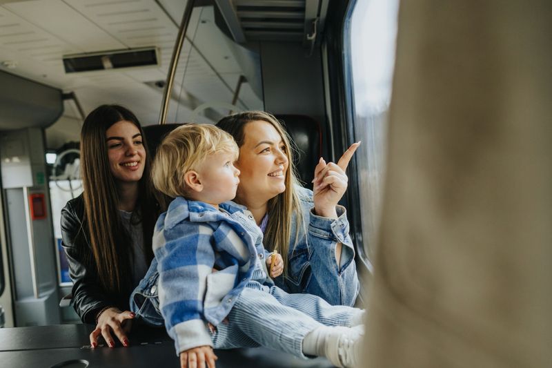 Young lesbian couple taking their cute blond baby boy on a first journey by train