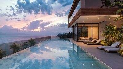 Modern house with infinity pool overlooking ocean at sunset.