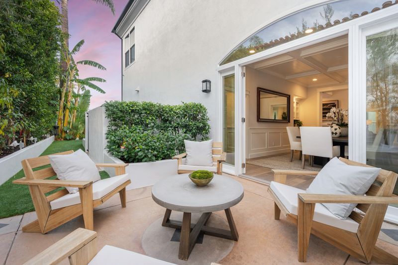 An outdoor patio with tables and chairs near a dining area