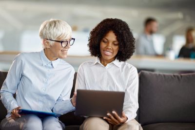 Two women collaborating with a laptop.