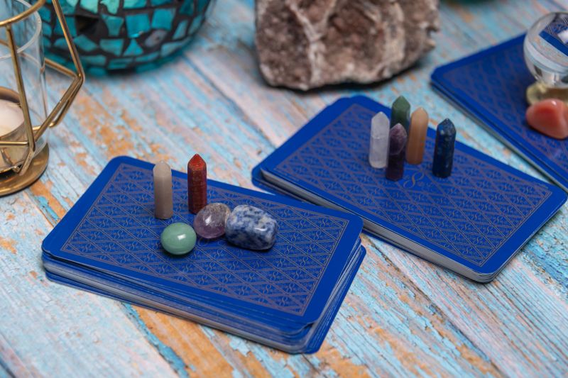 An intimate tarot reading session arrangement featuring vibrant crystals, tarot cards, and a geode on a rustic wooden table