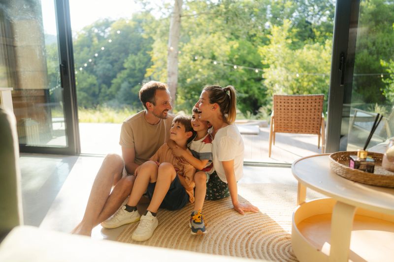 Portrait of a beautiful cheerful family with tho young children, spending quality time together in their home