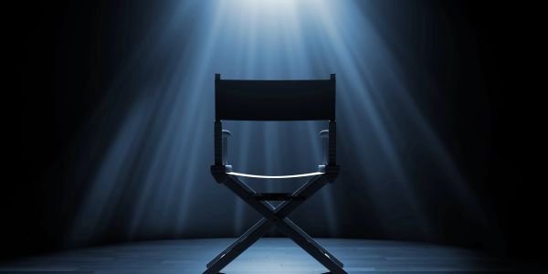 A solitary director's chair illuminated by spotlight.