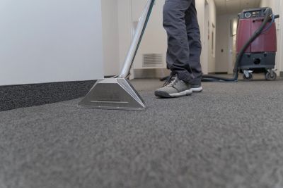 Person cleaning carpet with professional equipment.