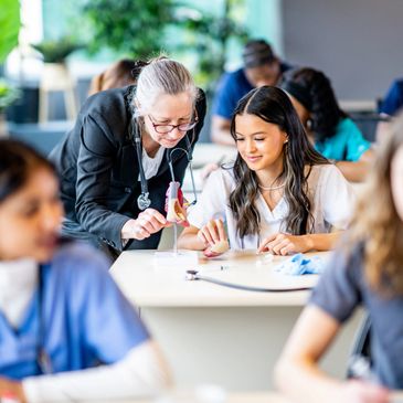 Teacher explaining a model to a student in classroom.