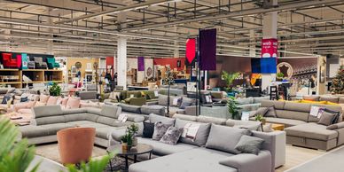 Spacious furniture showroom with various sofas and living room setups.