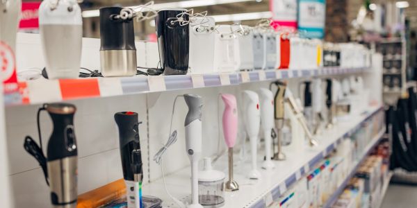 Row of hand blenders on store shelf.